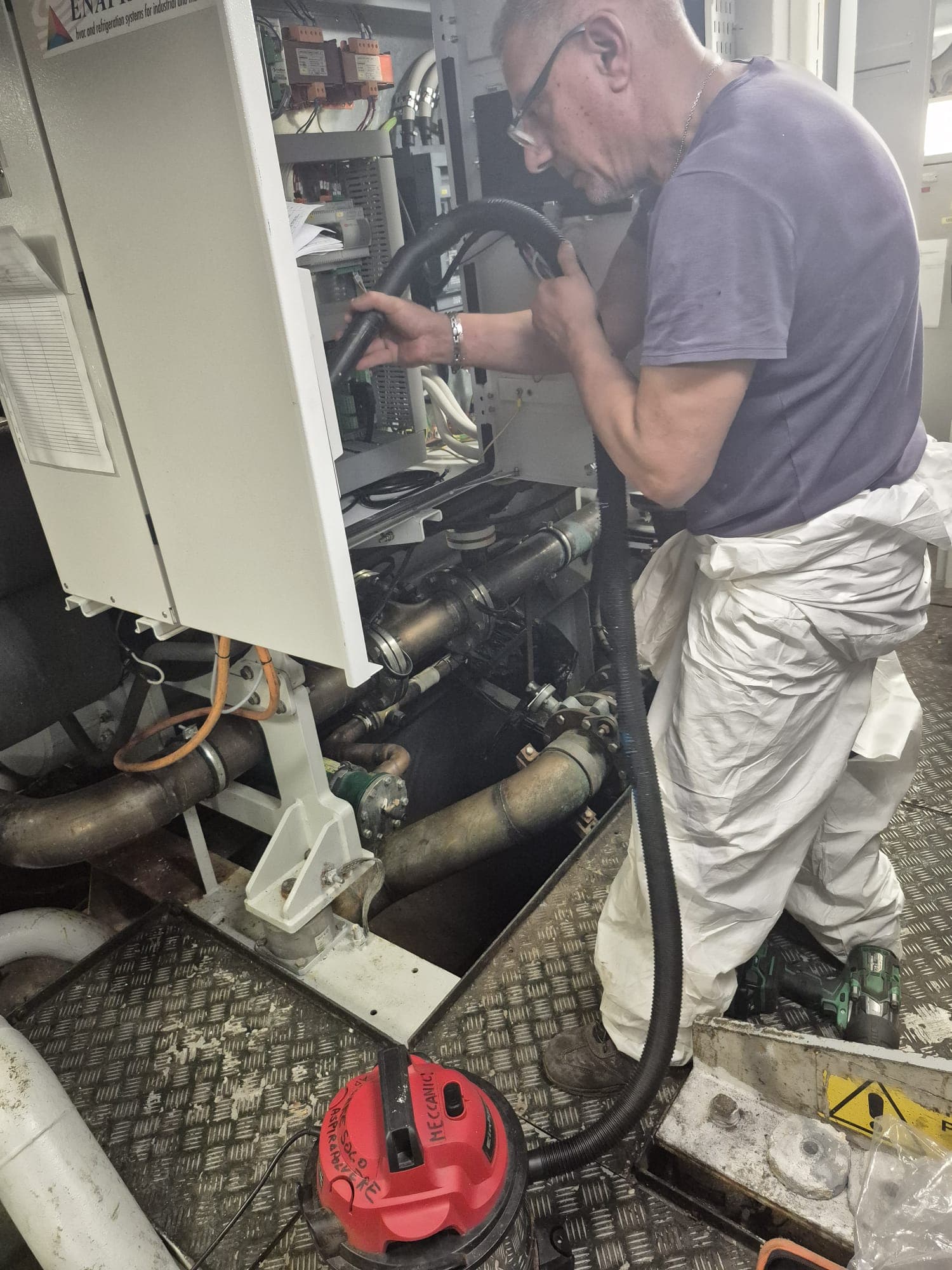 Technician cleaning a unit on board